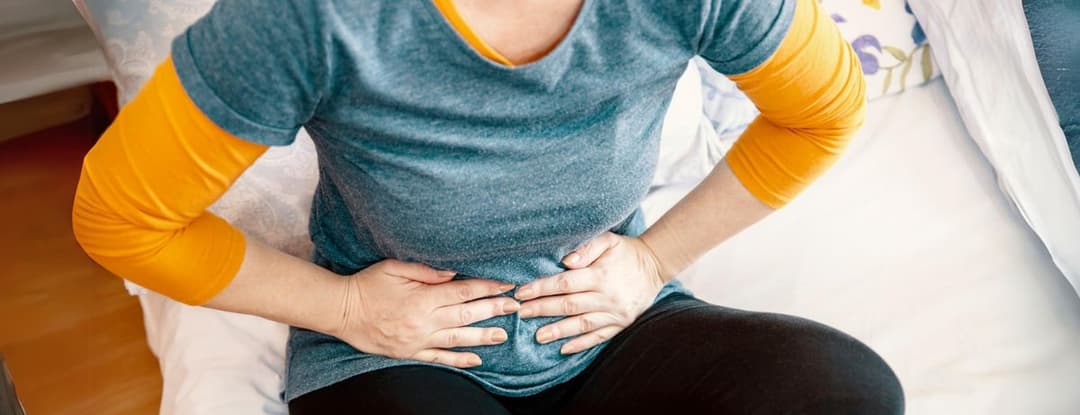 woman gripping stomach in pain